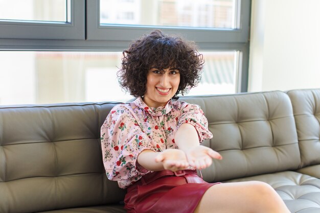 Young pretty woman sitting on a leather sofa