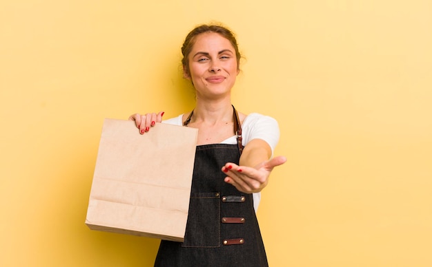 Young pretty woman smiling happily with friendly and offering and showing a concept fast food courier concept