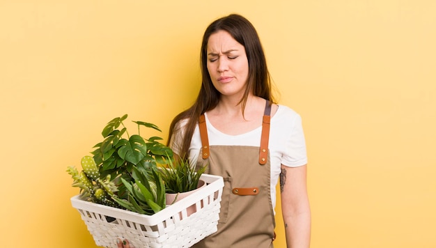 笑顔でフレンドリーに見える若いきれいな女性は、5番目の植物の概念を示しています