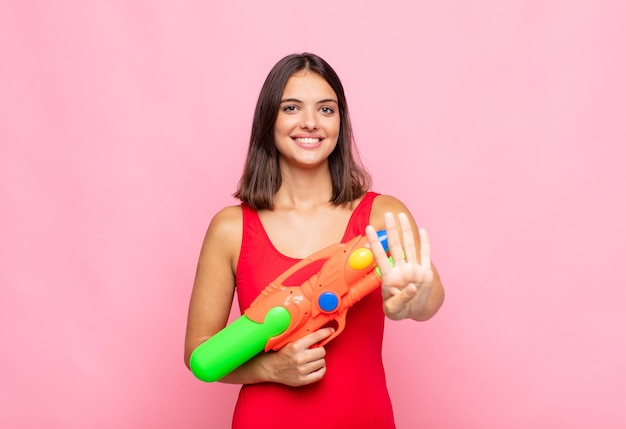 Young pretty woman smiling and looking friendly, showing number four or fourth with hand forward, counting down. summer concept