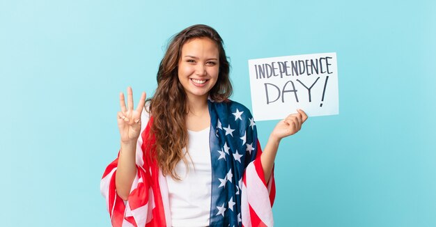 Young pretty woman smiling and looking friendly, showing number three independence day concept