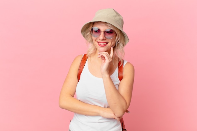 Young pretty woman smiling with a happy, confident expression with hand on chin. summer tourist concept