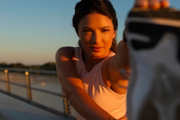 Foto giovane bella donna che si allunga la gamba durante l'esercizio sul ponte