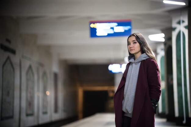 Young pretty woman waiting for the train in subway platform Night