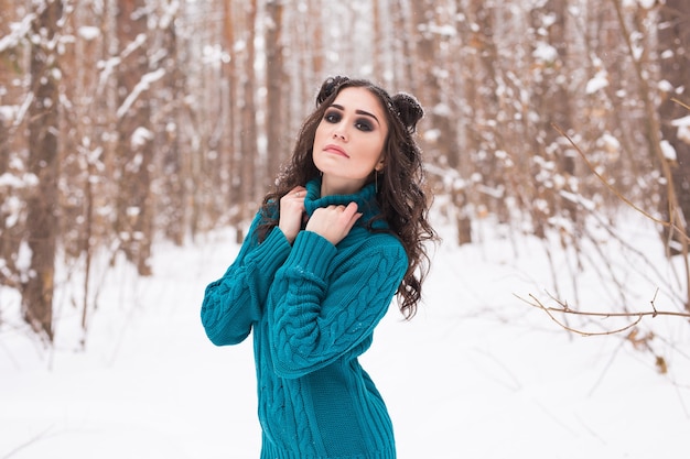 Молодая красивая женщина гуляет в зимнем снежном парке в солнечный день
