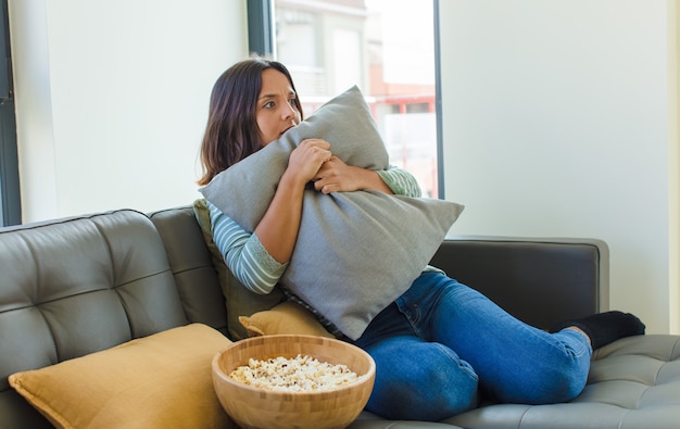 Young pretty woman watching tv at home