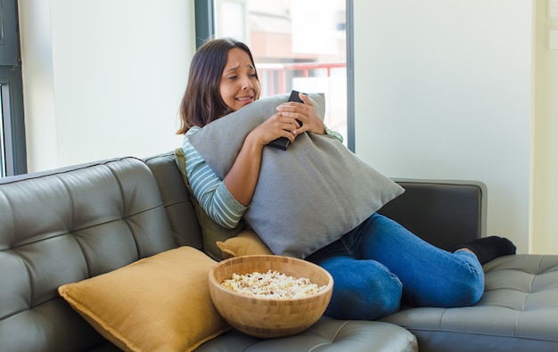 Young pretty woman watching tv at home