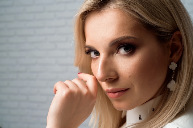 Young pretty woman wearing white shirt. Studio background.