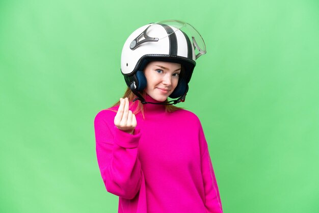 Фото Молодая красивая женщина в мотоциклетном шлеме на изолированном фоне хроматического ключа делает жест денег