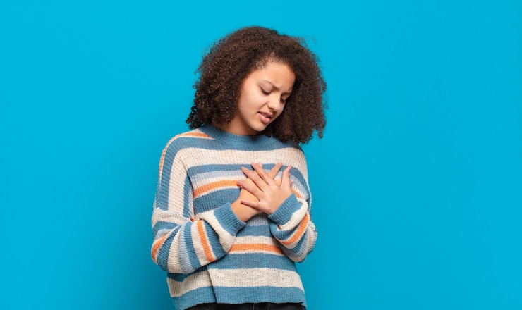 Photo young pretty woman with afro hair and striped sweater posing on blue wall