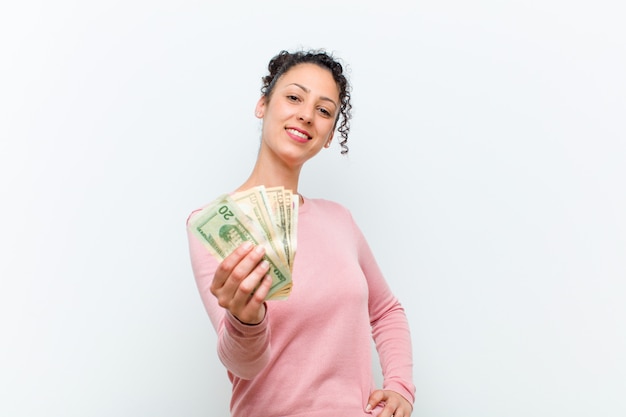 Young pretty woman with banknotes against white wall