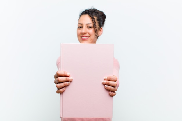 Young pretty woman with books against white wall