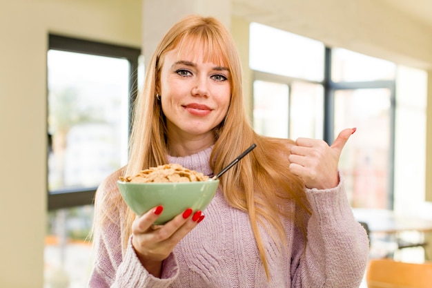 Young pretty woman with a breakfast flakes bowl at home interior