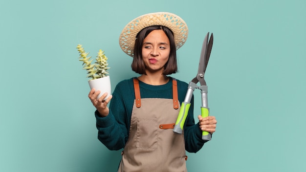 Giovane donna graziosa con un cactus. concetto di agricoltore