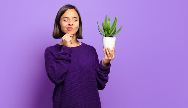 Giovane donna graziosa con un cactus