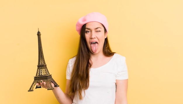 Young pretty woman with cheerful and rebellious attitude joking and sticking tongue out paris concept