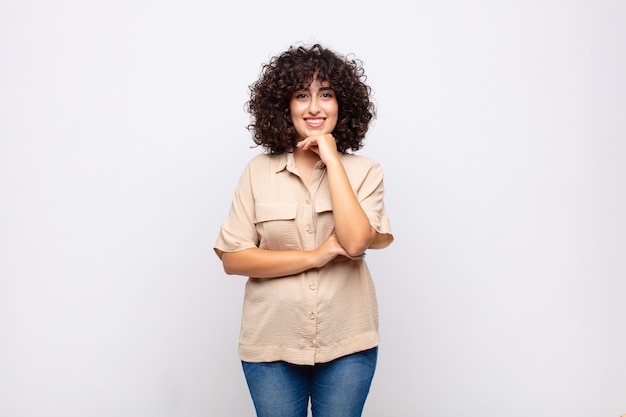 young pretty woman with curly hair and beige shirt