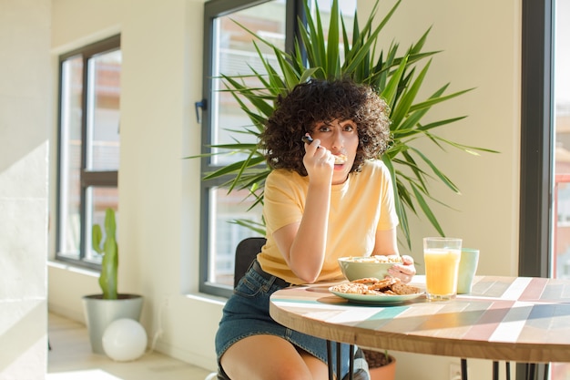 写真 屋内で巻き毛の若いきれいな女性