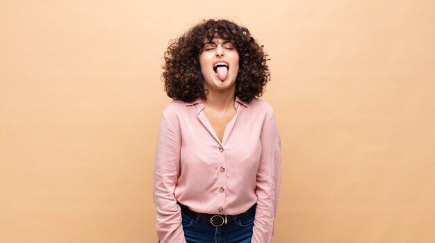 young pretty woman with curly hair and a pink shirt