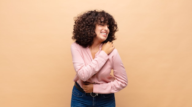 young pretty woman with curly hair and a pink shirt