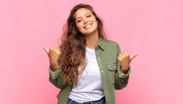 young pretty woman with green denim open shirt posing on pink wall