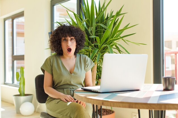 Photo young pretty woman with a laptop on a table