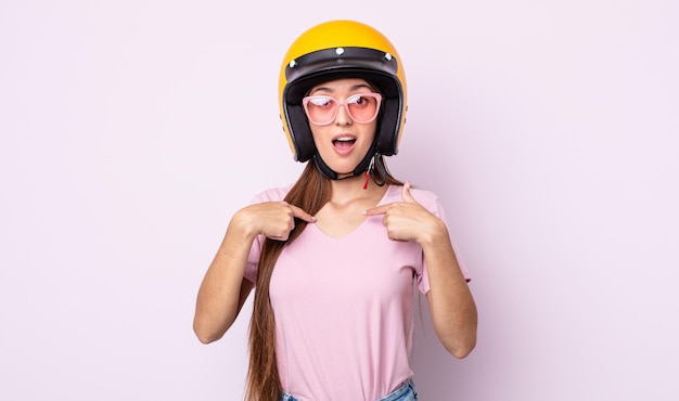 バイクのヘルメットを持つ若いきれいな女性。