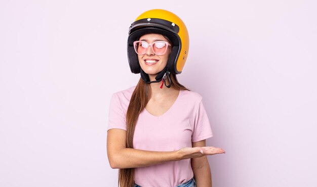 バイクのヘルメットを持つ若いきれいな女性。