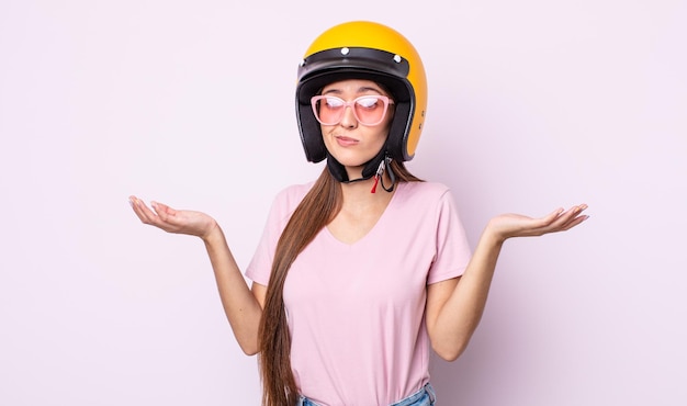 バイクのヘルメットを持つ若いきれいな女性。