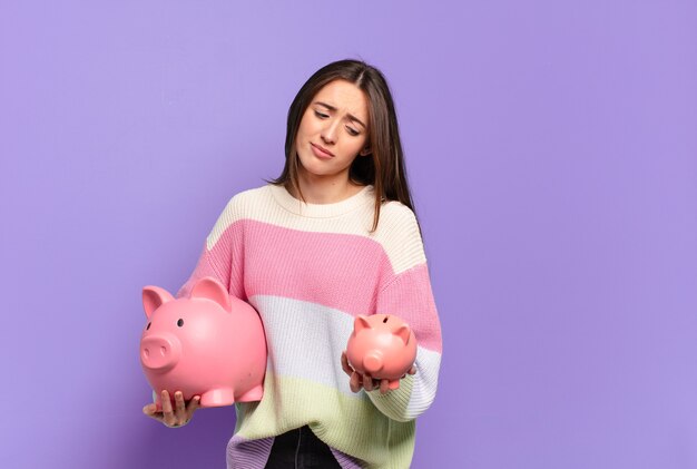 Young pretty woman with a piggy bank