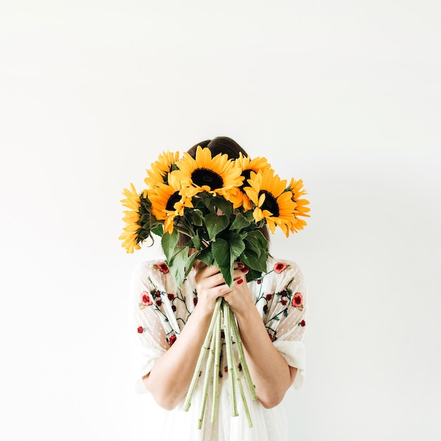 Young pretty woman with sunflowers bouquet on white.