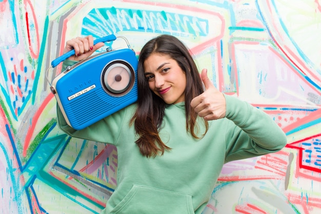 Young pretty woman with a vintage radio  graffiti wall