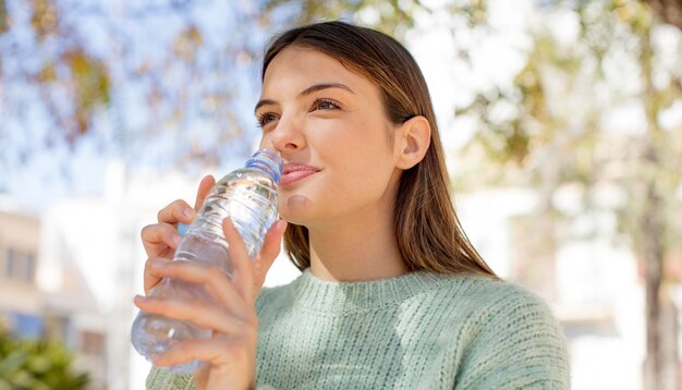 Foto giovane donna graziosa con una bottiglia d'acqua