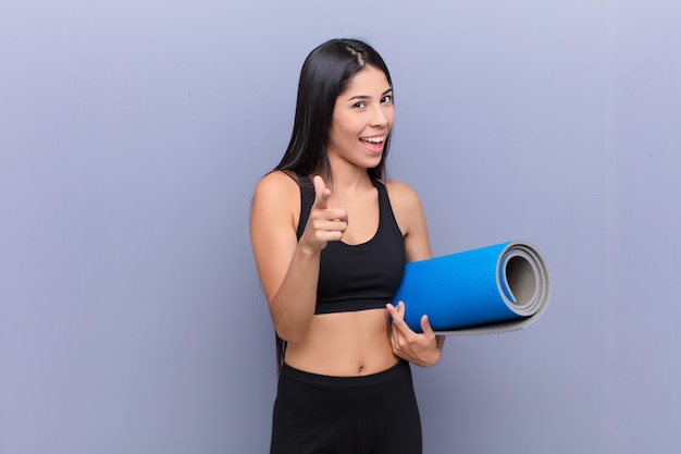 Young pretty woman with a yoga mat