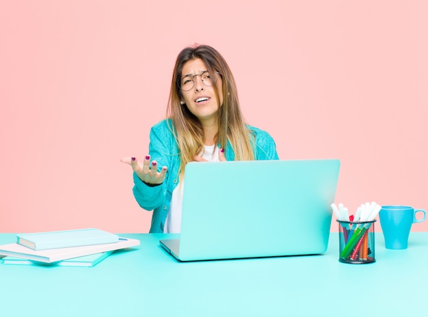 Young pretty woman working with a laptop feeling happy and in love