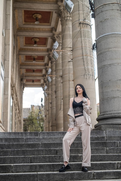 Young prety woman wear fashion white cloth pose outdoor against a old house in city