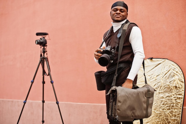 Young professional african american videographer holding professional camera with pro equipment Afro cameraman wearing black duraq making a videos