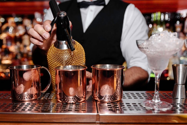 Foto un giovane barista professionista prepara cocktail per i suoi clienti al lavoro. concetto di professione