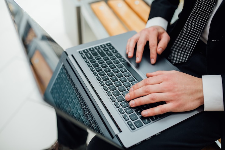 Photo young professional businessman  using modern laptop, close-up of male hands typing on notebook computer