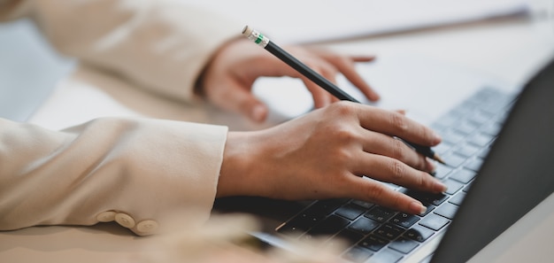 Foto giovane imprenditrice professionale lavorando sul suo progetto durante la digitazione sul computer portatile