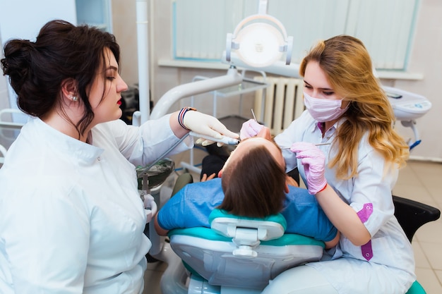 Young professional doctor dentist in a modern office with dental equipment. the concept of health insurance and free dental care. prosthetics and installation of veneers