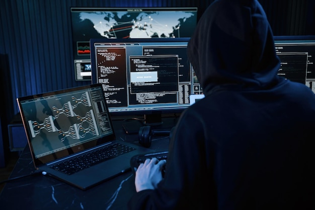 Young professional female hacker is indoors by computer with lot of information on displays