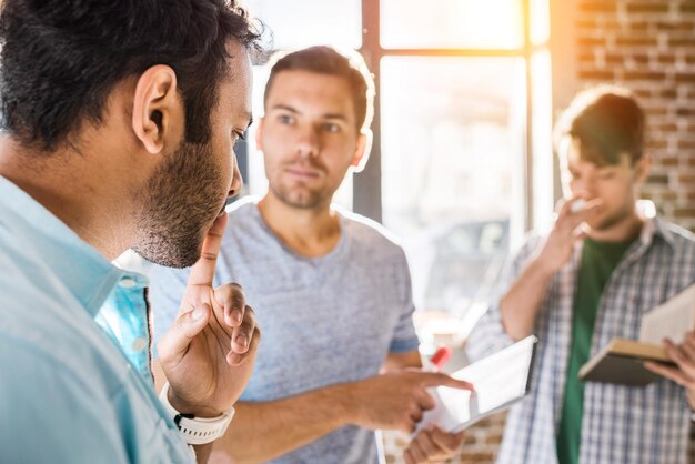 Giovane gruppo di professionisti che lavora su un nuovo progetto imprenditoriale in un ufficio per piccole imprese