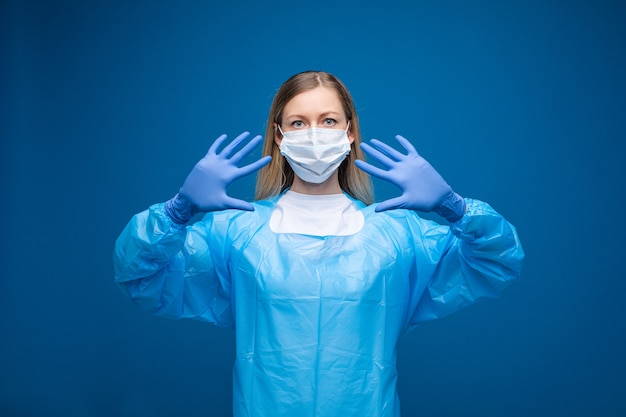 Young professional medic standing in protective face mask