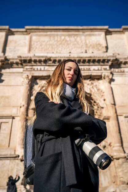 Foto giovane fotografo professionista che esamina la macchina fotografica con la sua attrezzatura