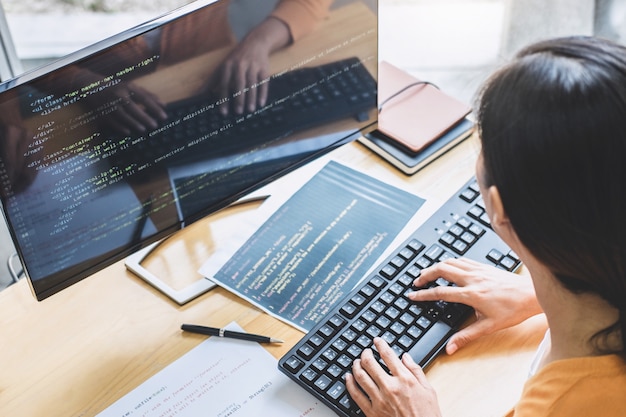 Photo young professional programmer working at developing programming and website working in a software develop company office, writing codes and typing data code, programming with html, php and javascript