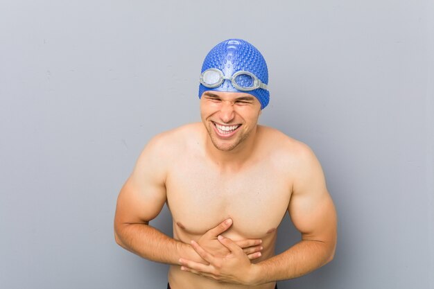 Young professional swimmer man laughing and having fun.