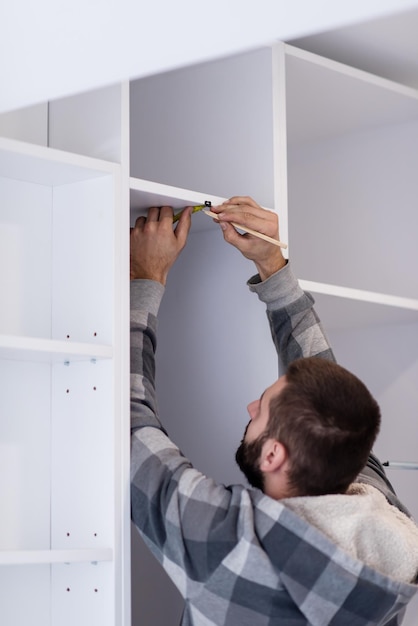 young professional worker writing the measures during installation a new stylish modern kitchen furniture