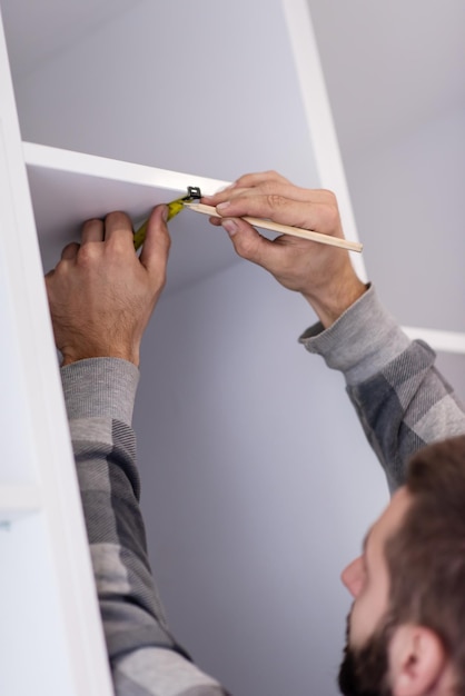 young professional worker writing the measures during installation a new stylish modern kitchen furniture