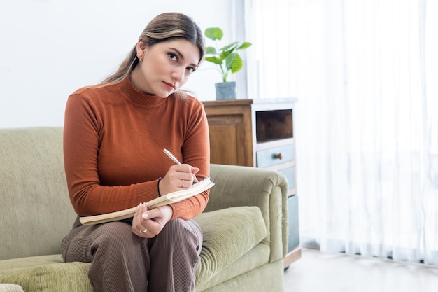 写真 療法中にカメラを見てメモを取る若い心理学者